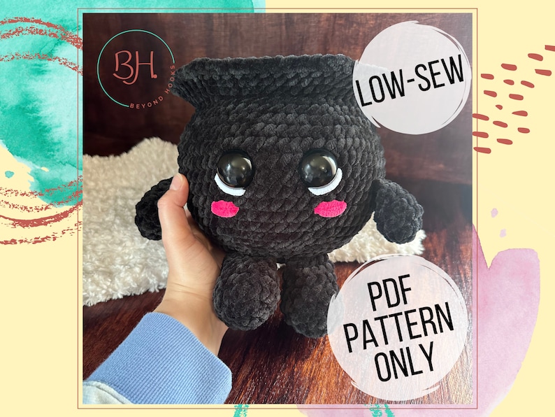 May include: A black crocheted amigurumi toy with large eyes and pink cheeks. The toy is shaped like a cauldron and has a low-sew design. The image includes the text "LOW-SEW" and "PDF PATTERN ONLY".