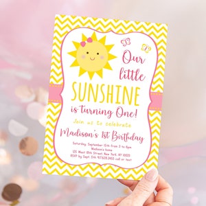 May include: A yellow and pink birthday invitation with a smiling sun illustration and the text "Our little SUNSHINE is turning One!"  Join us to celebrate Madison's 1st Birthday. Saturday, September 15th from 3 to 6pm. Madison's home. 125 West 18th Street New York, NY 10000. RSVP by Sept 5th 97628.2455 call or text.
