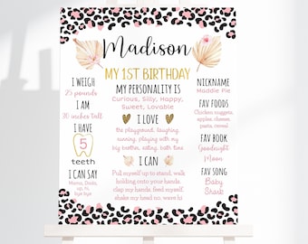 Puede incluir: Un cartel de primer cumpleaños de estampado de leopardo rosa y negro con detalles dorados. El cartel incluye el nombre "Madison" y detalles sobre el primer año del niño, incluyendo su peso, altura, comidas favoritas y actividades.