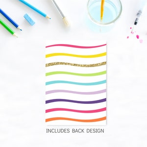 May include: A white card with a rainbow wave pattern and gold glitter. The text "INCLUDES BACK DESIGN" is at the bottom of the card.