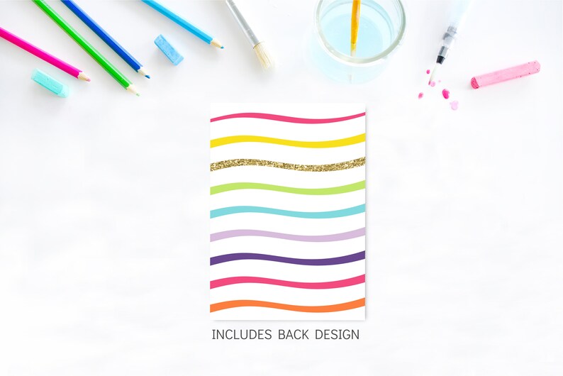 May include: A white card with a rainbow wave pattern and gold glitter. The text "INCLUDES BACK DESIGN" is at the bottom of the card.