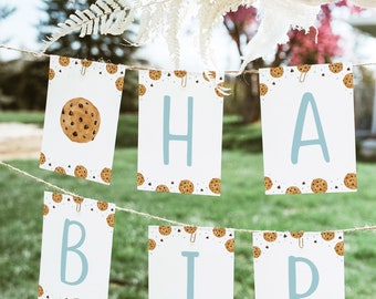 Op de afbeelding: Een banner met het woord "Happy Birthday" gespeld op individuele kaarten. Elke kaart heeft een witte achtergrond met een patroon van bruine chocoladekoekjes en witte chocoladechips. De letters zijn lichtblauw.
