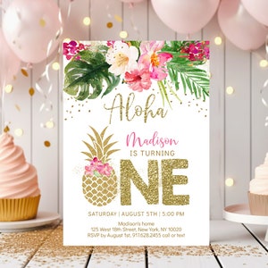 May include: A tropical-themed first birthday party invitation with a gold glitter pineapple and the text "Aloha Madison is turning ONE". The invitation is decorated with pink and white flowers and green leaves. The text "Saturday | August 5th | 5:00 PM" is at the bottom of the invitation, along with the address and RSVP information.