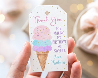 Pode incluir: Uma etiqueta de agradecimento branca com pontos de glitter dourado. A etiqueta apresenta uma ilustração de desenho animado de um cone de sorvete de três bolas com sorvete rosa, azul e roxo. O texto na etiqueta diz "Obrigado por tornar meu aniversário tão doce! Com amor, Madison."