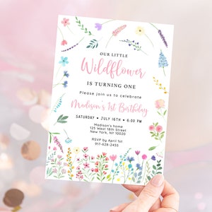 Puede incluir: Una invitaci&oacute;n blanca con un borde floral rosa. El texto dice "Nuestra peque&ntilde;a Wildflower est&aacute; cumpliendo un a&ntilde;o. Por favor, &uacute;nase a nosotros para celebrar el primer cumplea&ntilde;os de Madison. S&aacute;bado 16 de julio, 6:00 PM. La casa de Madison, 125 West 18th Street, Nueva York, NY 10020. RSVP antes del 1 de abril, 917-628-2455."