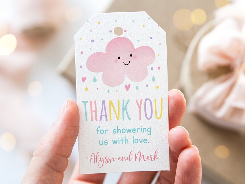 May include: A white thank you tag with a pink cloud with a happy face and raindrops. The text reads "Thank You for showering us with love. Alyssa and Mark".
