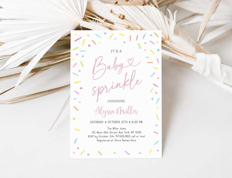 May include: A pink and white baby sprinkle invitation with colorful sprinkles around the border. The text reads "It's a Baby Sprinkle Honoring Alyssa Miller Saturday October 15th 6:00 PM The Miller home 125 West 18th Street, New York, NY 10020 RSVP by October 5th: 917.628.2455 call or text Registered at Store Names Here"