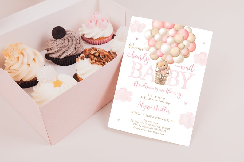 May include: A pink and gold baby shower invitation with a teddy bear in a hot air balloon made of balloons. The text reads "We can bearly wait BABY Madison is on the way".