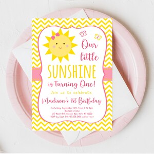 May include: Yellow and pink first birthday party invitation with a sun and butterflies. The text reads "Our little SUNSHINE is turning One!" and includes the date, time, and location of the party.
