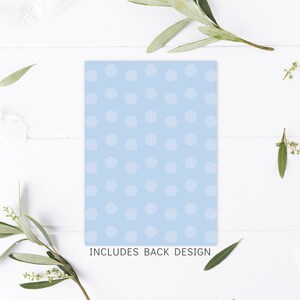 May include: A light blue card with white polka dots. The text "INCLUDES BACK DESIGN" is printed at the bottom of the card.