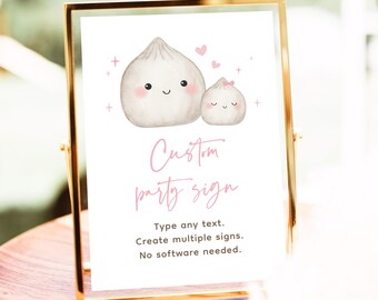 May include: A gold-framed sign with a watercolor illustration of two smiling dumplings, pink hearts, and text that reads "Custom party sign." The sign also states "Type any text. Create multiple signs. No software needed."