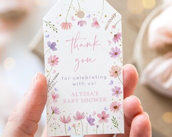 Può includere: Un'etichetta di ringraziamento bianca con un design floreale rosa e glitter dorati. Il testo recita "Grazie per aver festeggiato con noi! Baby Shower di Alyssa".