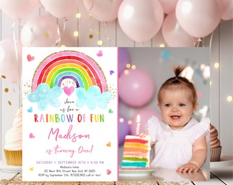 Puede incluir: Una invitación a una fiesta de primer cumpleaños con temática de arcoíris con una foto de una niña. La invitación presenta un arcoíris colorido con nubes y purpurina dorada. El texto dice "Únete a nosotros para un arcoíris de diversión Madison cumple un año!" con la fecha y la hora de la fiesta.