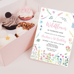 Puede incluir: Una invitaci&oacute;n blanca con un borde floral y el texto "Our Little Wildflower is Turning One" en rosa. La invitaci&oacute;n incluye detalles para la fiesta del primer cumplea&ntilde;os de Madison, incluyendo la fecha, la hora, la ubicaci&oacute;n y la informaci&oacute;n de RSVP.