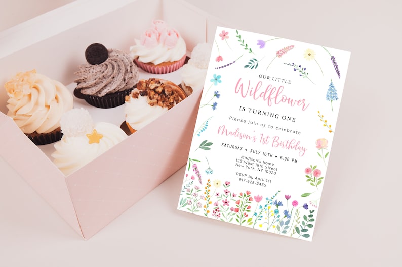 Puede incluir: Una invitaci&oacute;n blanca con un borde floral y el texto "Our Little Wildflower is Turning One" en rosa. La invitaci&oacute;n incluye detalles para la fiesta del primer cumplea&ntilde;os de Madison, incluyendo la fecha, la hora, la ubicaci&oacute;n y la informaci&oacute;n de RSVP.