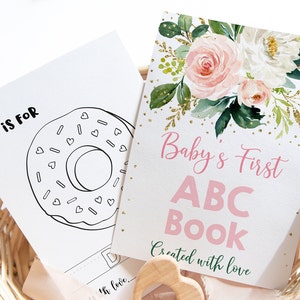 May include: A pink and white floral design with gold glitter accents on a white card. The card says "Baby's First ABC Book Created with Love".