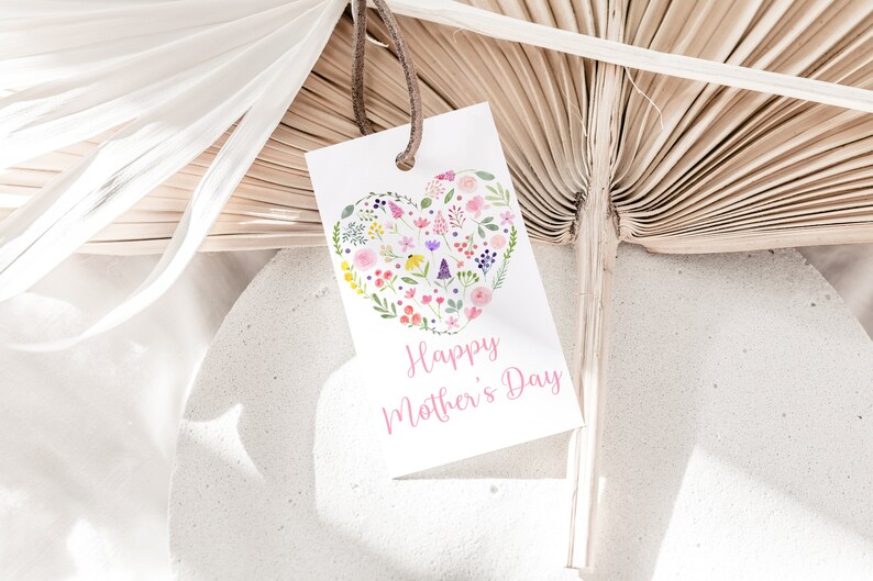 May include: White card with a pink heart filled with colorful flowers and the text "Happy Mother's Day" in pink lettering.