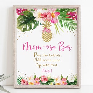 May include: A printable sign for a "Mom-osa Bar" with a tropical theme. The sign features a gold pineapple, pink flowers, and green leaves. The text on the sign reads: "Mom-osa Bar, Pour the bubbly, Add some juice, Top with fruit, Enjoy!"