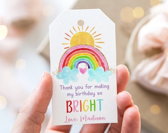 May include: A white tag with a rainbow, sun, and clouds. The text on the tag reads "Thank you for making my birthday so BRIGHT Love, Madison".