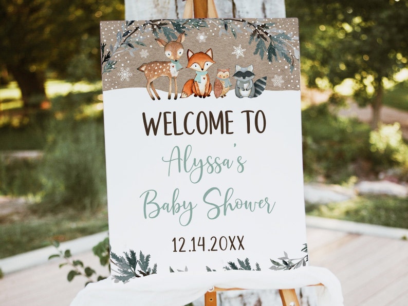 May include: Welcome to Alyssa's Baby Shower sign with a winter woodland theme. The sign features a deer, fox, owl, and raccoon in a snowy forest setting. The date 12.14.20XX is printed at the bottom.