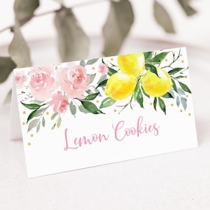 May include: A white card with pink flowers and yellow lemons on a branch. The card has gold glitter dots and the text "Lemon Cookies" in pink.