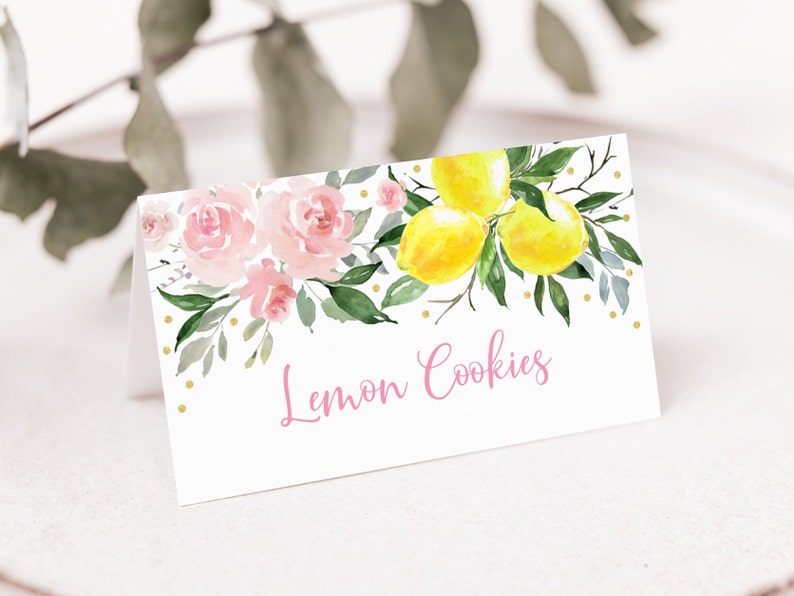May include: A white card with pink flowers and yellow lemons on a branch. The card has gold glitter dots and the text "Lemon Cookies" in pink.