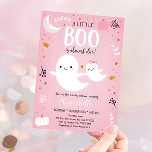 Puede incluir: Una invitaci&oacute;n de baby shower rosa con un dise&ntilde;o de fantasma y calabaza. El texto dice "A Little Boo is almost due!" e incluye detalles del evento, como la fecha, la hora y la ubicaci&oacute;n.
