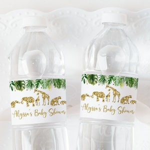 Può includere: Due bottiglie d'acqua in plastica trasparente con etichette bianche. Le etichette presentano un design a foglie tropicali verdi con silhouette di animali in glitter dorato. Il testo sulle etichette recita "Baby Shower di Alyssa".