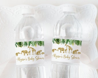 Könnte beinhalten: Zwei durchsichtige Plastikwasserflaschen mit weißen Etiketten. Die Etiketten haben ein grünes tropisches Blattdesign mit goldenen Glitzer-Tiersilhouetten. Der Text auf den Etiketten lautet "Alyssa's Baby Shower".