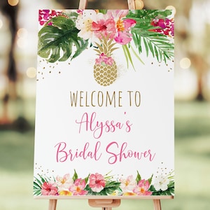 May include: A white welcome sign with gold lettering and pink floral accents. The sign reads "Welcome to Alyssa's Bridal Shower".