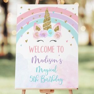 May include: Welcome to Madison's Magical 5th Birthday sign with a unicorn illustration. The unicorn has a gold glitter horn and a floral crown. The background is a watercolor rainbow with pink, purple, and blue colors.