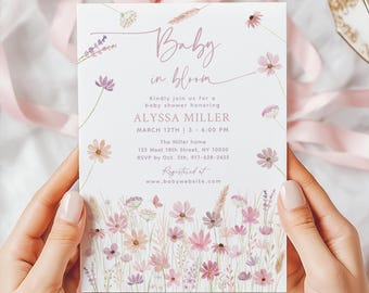 May include: A baby shower invitation with a floral design. The invitation features the text "Baby in bloom" and event details, including the name Alyssa Miller, date, time, and location. The invitation is held by a person.