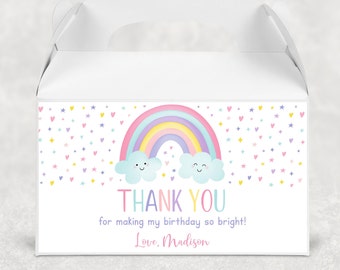 May include: A white favor box with a rainbow, clouds, and stars design. The box has a handle and says "Thank You for making my birthday so bright! Love, Madison".