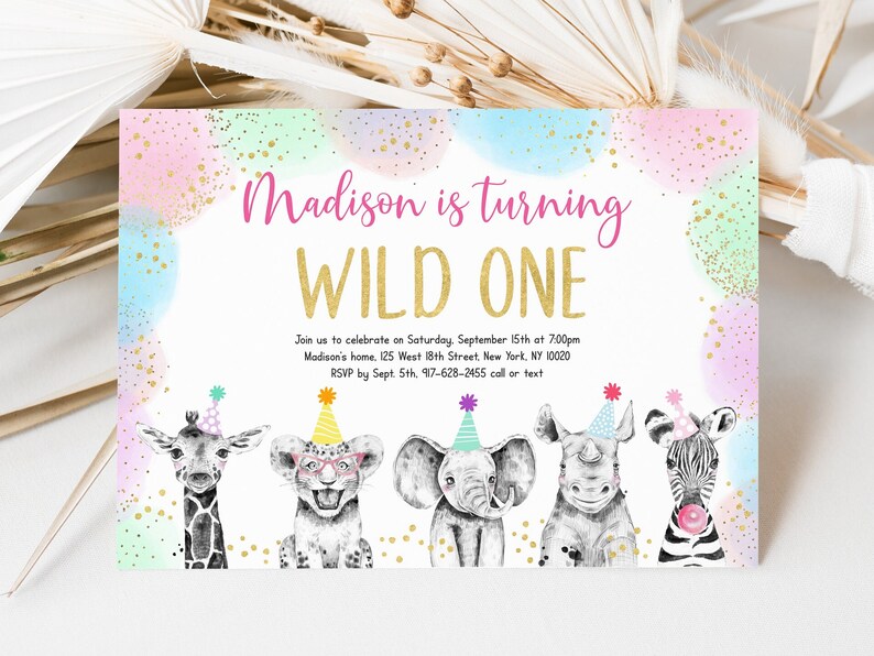May include: A pink, blue, and green watercolor background with gold glitter confetti. The text "Madison is turning WILD ONE" is in gold lettering. The invitation includes details for a birthday party, including the date, time, location, and RSVP information. The bottom of the invitation features a giraffe, lion, elephant, rhinoceros, and zebra wearing party hats.