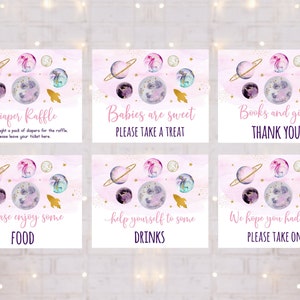 May include: Six pink and gold space-themed baby shower signs with watercolor planets and stars. The signs say "Diaper Raffle", "Babies are sweet, Please take a treat", "Books and gifts, Thank you", "Please enjoy some food", "Help yourself to some drinks", and "We hope you had fun! Please take one".