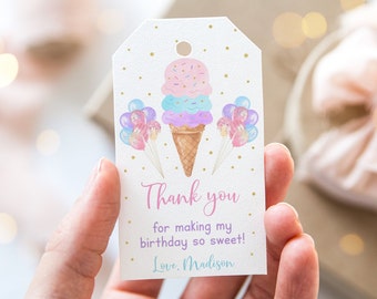 Pode incluir: Uma etiqueta de agradecimento branca com pontos de glitter dourado. A etiqueta apresenta uma ilustração em aquarela de um cone de sorvete de três bolas com sorvete rosa, azul e roxo. O cone de sorvete é cercado por balões rosa, azuis e brancos. O texto na etiqueta diz "Obrigado por tornar meu aniversário tão doce! Com amor, Madison."
