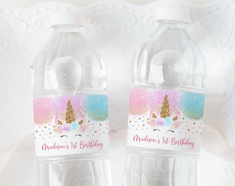 May include: Two clear plastic water bottles with labels featuring a unicorn with a gold horn and pink and blue glitter. The labels also say "Madison's 1st Birthday".