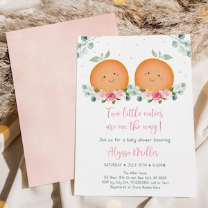 Puede incluir: Una invitaci&oacute;n a un baby shower con un dise&ntilde;o floral rosa y blanco. Dos frutas naranjas con caras sonrientes est&aacute;n en la parte superior de la invitaci&oacute;n. El texto dice "&iexcl;Dos peque&ntilde;os encantos est&aacute;n en camino!" y "&Uacute;nete a nosotros para un baby shower en honor a Alyssa Miller".
