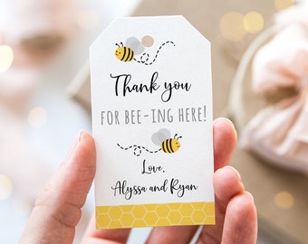 May include: White thank you tag with a bee design. The tag says "Thank you for bee-ing here!" and "Love, Alyssa and Ryan".