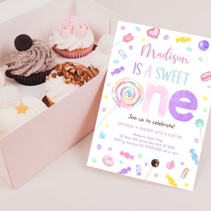 May include: A box of cupcakes and a colorful invitation. The invitation reads "Madison IS A SWEET ONE" with candy illustrations. Cupcakes have various toppings, including chocolate, nuts, and frosting. The invitation includes event details.