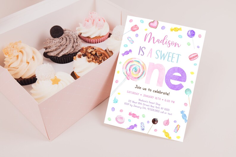 May include: A box of cupcakes and a colorful invitation. The invitation reads "Madison IS A SWEET ONE" with candy illustrations. Cupcakes have various toppings, including chocolate, nuts, and frosting. The invitation includes event details.