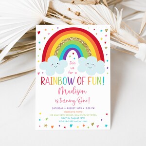 Peut inclure: Une invitation &agrave; un premier anniversaire sur le th&egrave;me de l'arc-en-ciel avec un arc-en-ciel color&eacute; avec des paillettes dor&eacute;es, deux nuages avec des visages souriants et le texte "Rejoignez-nous pour un arc-en-ciel de plaisir&nbsp;! Madison a un an&nbsp;!" L'invitation comprend la date, l'heure, le lieu et les informations RSVP.