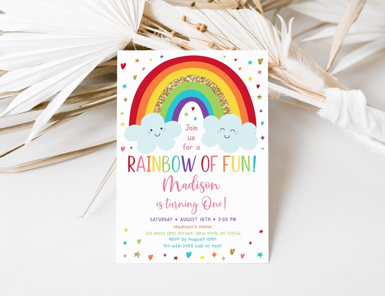 Peut inclure: Une invitation &agrave; un premier anniversaire sur le th&egrave;me de l'arc-en-ciel avec un arc-en-ciel color&eacute; avec des paillettes dor&eacute;es, deux nuages avec des visages souriants et le texte "Rejoignez-nous pour un arc-en-ciel de plaisir&nbsp;! Madison a un an&nbsp;!" L'invitation comprend la date, l'heure, le lieu et les informations RSVP.