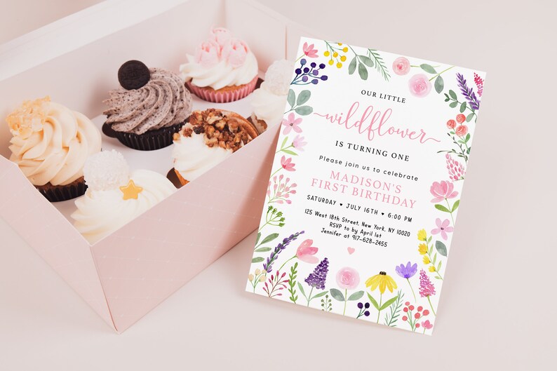 May include: A floral-themed first birthday invitation for a girl named Madison. The invitation features a watercolor design with pink, purple, yellow, and green flowers. The text reads "Our Little Wildflower is Turning One. Please join us to celebrate Madison's First Birthday. Saturday, July 16th, 6:00 PM. 125 West 18th Street, New York, NY 10000. RSVP to by April 1st. Jennifer at 417-628-2455."