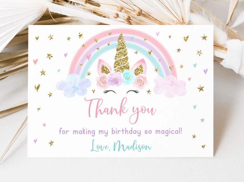 May include: A thank you card with a unicorn and rainbow design. The unicorn has a gold glitter horn and a pink and purple flower crown. The rainbow is pastel pink, purple, and blue. The card says "Thank you for making my birthday so magical! Love, Madison."