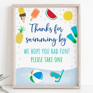 May include: A blue and white sign with the text "Thanks for swimming by. We hope you had fun! Please take one."  The sign is decorated with summer-themed illustrations, including a pineapple, ice cream cone, popsicle, watermelon, sun, beach ball, and flippers.