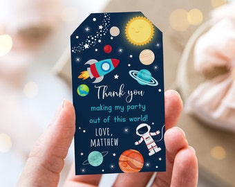 May include: Blue thank you tag with a rocket, planets, stars, and an astronaut. The text reads "Thank you making my party out of this world! Love, Matthew".