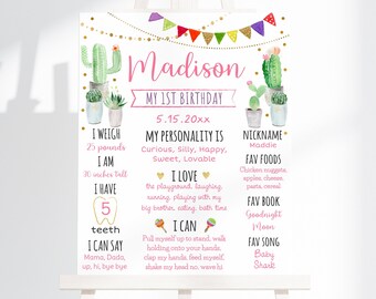 Pode incluir: Um cartaz de primeiro aniversário rosa e dourado com tema de cacto. O cartaz diz "Madison Meu 1º Aniversário 5.15.20xx". Também lista detalhes sobre a criança, como seu peso, altura, comidas favoritas e livro favorito.