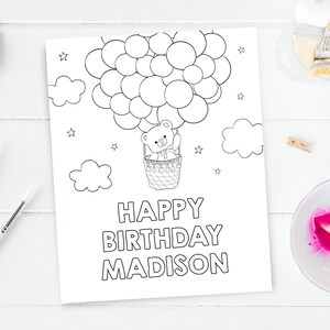 May include: A black and white coloring page featuring a teddy bear in a hot air balloon with the text "Happy Birthday Madison".