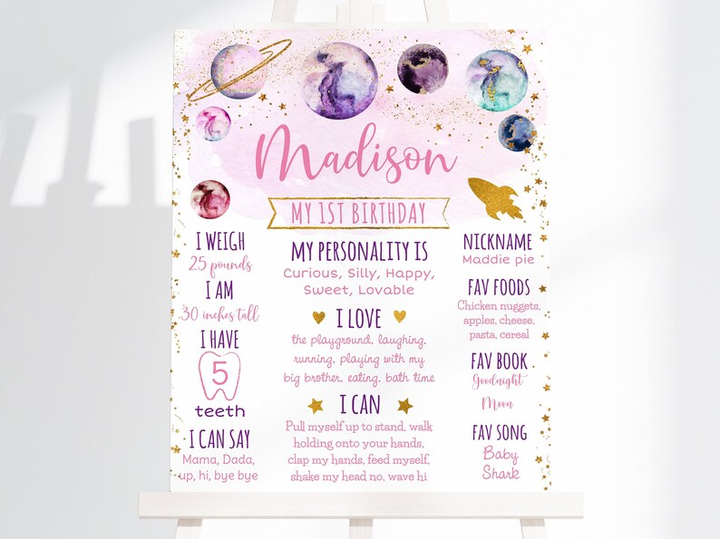 May include: A pink and purple watercolor-style poster with gold stars and planets. The poster says "Madison My 1st Birthday" and lists details about the child, including their weight, height, favorite foods, and favorite book.